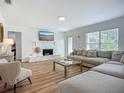 Bright living room features a stone fireplace, large window, and comfortable sectional sofa at 912 Ponderosa Pine Ln, Sarasota, FL 34243