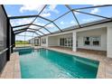 Inviting screened-in pool with a spillover spa, brick pavers, and a picturesque backyard view at 10309 Longmeadow Ave, Parrish, FL 34219