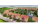 Aerial view of townhouses with terra cotta roofs surrounding a pond at 1512 3Rd Street E Cir, Palmetto, FL 34221
