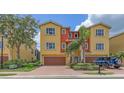 Attractive two-story townhouse featuring a brick paved driveway, garage, and vibrant landscaping at 1512 3Rd Street E Cir, Palmetto, FL 34221