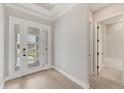 Welcoming foyer with light wood floors, a glass front door, and a glimpse into the adjacent bathroom at 15813 San Lazzaro Ave, Bradenton, FL 34211