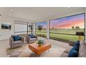 Bright living room with plush seating, a mid-century coffee table, and large windows offering stunning golf course views at 15813 San Lazzaro Ave, Bradenton, FL 34211