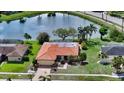 Beautiful single-Gathering home with a lovely pond view, a tile roof and lush landscaping at 1677 Fleetwood Dr, Sarasota, FL 34232