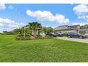 Lush front lawn with tropical landscaping and a brick driveway complements this inviting home at 17204 Bullhorn Cir, Punta Gorda, FL 33982