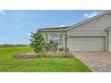 A single Gathering home with a well kept lawn, clean landscaping, and a beautiful blue sky above at 17817 Pastureland Ave, Lakewood Ranch, FL 34211