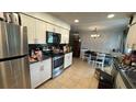 The kitchen features stainless steel appliances, and tiled floors, next to a dining space at 23067 Elmira Blvd, Punta Gorda, FL 33980