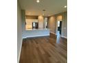 A modern kitchen view from the living area with stainless steel appliances and hardwood floors at 24803 Buckingham Way, Port Charlotte, FL 33980