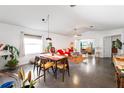 Open-concept living and dining area with modern lighting, polished concrete floors and view of the front yard at 2511 Lantana Ln, Palmetto, FL 34221
