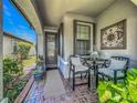 Inviting front porch featuring neutral decor, comfortable seating, and attractive plants at 2525 Daisy Dr, North Port, FL 34289