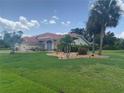 Beautiful single-story home featuring a red tile roof, manicured lawn, and mature palm trees on a sunny day at 25433 Colon Dr, Punta Gorda, FL 33983