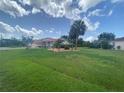 Spacious home with a red tile roof surrounded by a lush green lawn and mature trees on a sunny day at 25433 Colon Dr, Punta Gorda, FL 33983