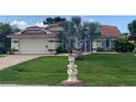Inviting home boasts a red tile roof, manicured lawn, and decorative seahorse mailbox in a lush landscape at 25433 Colon Dr, Punta Gorda, FL 33983