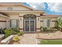 Inviting home entrance featuring a decorative security door and well-maintained, colorful landscaping at 25433 Colon Dr, Punta Gorda, FL 33983