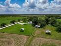 Aerial view of large property with outbuildings, mature trees, paddocks and pond at 26147 L And J Rd, Myakka City, FL 34251