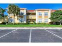 A view of the exterior of a multi-Gathering building with ample parking and landscaping at 3005 Chianti Ct # 103, Sarasota, FL 34237