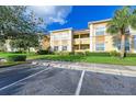 Multi-Gathering building featuring well-manicured lawn, trees, and paved parking at 3005 Chianti Ct # 103, Sarasota, FL 34237