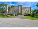 Well-maintained condo building with covered parking, manicured lawns, and mature landscaping at 3680 Ironwood Circle # 704-L, Bradenton, FL 34209