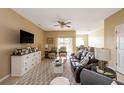 Living room with a ceiling fan, leather sofa, modern furniture and large tv at 3698 Parkridge Cir # 26-104, Sarasota, FL 34243