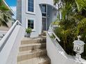 Inviting front entrance with tiled steps, white railings, and lush tropical landscaping at 3959 Somerset Dr # 5, Sarasota, FL 34242