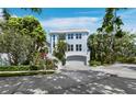 Charming two-story home with a light blue exterior, lush landscaping, and a well-maintained front yard at 3959 Somerset Dr # 5, Sarasota, FL 34242