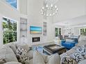 Bright and airy living room with high ceilings, fireplace, and modern chandelier at 3959 Somerset Dr, Sarasota, FL 34242