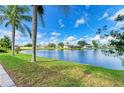 Picturesque waterfront view featuring a serene lake surrounded by lush greenery and neighborhood homes at 4426 Useppa Dr, Bradenton, FL 34203