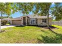 Well-manicured lawn complements this tan single story home and two car garage at 4845 Post Pointe Dr, Sarasota, FL 34233