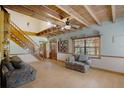 Inviting living room featuring exposed wood beams, a staircase, and two comfortable couches at 5034 257Th E St, Myakka City, FL 34251