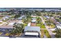 Aerial view of condo building featuring covered parking and well maintained landscaping near a scenic lake at 516 Parkdale Mews # 516, Venice, FL 34285