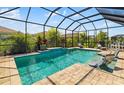 Relaxing screened-in pool area with in-pool seating and ample space for patio furniture and decor at 5750 Long Shore Loop, Sarasota, FL 34238
