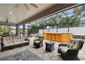 Spacious screened-in patio complete with comfortable seating, bar area, and stone fireplace at 5802 Alabaster Stone Ln, Apollo Beach, FL 33572