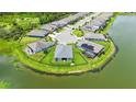 Areal view of home, pond, and surrounding community featuring lush landscaping, solar panels, and cul-de-sac at 5910 Hevena Ct, Palmetto, FL 34221