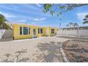 Bright yellow home with a shell driveway, covered carport, and tidy, low-maintenance landscaping at 627 Avenida Del Norte, Sarasota, FL 34242