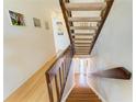 Staircase with wooden railing and white walls, leading to the upper or lower floors, enhanced by decorative wall art at 6840 Midnight Pass Rd # 6840, Sarasota, FL 34242