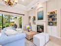 Bright living room with fireplace, built-in shelving, and sliding glass doors to lanai at 6851 Bay Hill Dr, Lakewood Ranch, FL 34202