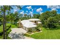 Luxury home showcasing meticulously maintained landscaping, expansive driveway, and a serene lakeside setting at 7404 Weeping Willow Blvd, Sarasota, FL 34241