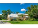 Beautiful home with a white tile roof, lush landscaping, and a spacious driveway, perfect for Gathering living at 7404 Weeping Willow Blvd, Sarasota, FL 34241