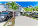 Charming townhome showcasing a well-kept lawn, vibrant landscaping, and a spacious driveway with cars at 8676 Ice Wine St, Sarasota, FL 34238