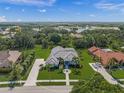 Beautifully landscaped property with a circular driveway, lush lawn, and a view of the lake at 8924 Misty Creek Dr, Sarasota, FL 34241