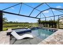 Stunning screened-in pool with a spa, a water feature, and a view of a peaceful pond at 9012 Tequila Sunrise Dr, Sarasota, FL 34241
