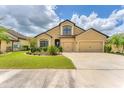 Traditional home with a three-car garage, manicured lawn, and trimmed hedges at 9123 Raes Creek Pl, Palmetto, FL 34221