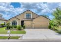 Traditional home with a three-car garage, manicured lawn, and trimmed hedges at 9123 Raes Creek Pl, Palmetto, FL 34221
