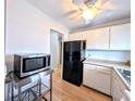 Bright kitchen with laminate floors, stainless microwave and black refrigerator at 1540 Pleasant Rd # G35, Bradenton, FL 34207