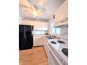 Cozy kitchen featuring white appliances, laminate floors, and ceiling fan at 1540 Pleasant Rd # G35, Bradenton, FL 34207
