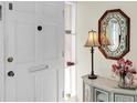 Bright foyer featuring a decorative mirror, elegant lamp, and floral arrangement on a marble-topped cabinet at 1060 Cockrill St # 1060, Venice, FL 34285