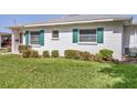 A close-up shot showing green shutters on the home's white siding and well-maintained landscaping at 1060 Cockrill St # 1060, Venice, FL 34285