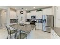 Modern kitchen with stainless steel appliances, granite countertops, and white cabinets at 10609 Great Cormorant Dr, Riverview, FL 33579
