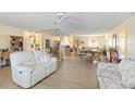 Open-concept living room with hardwood floors, a ceiling fan and views into the kitchen and dining areas at 1163 Nantucket Rd, Venice, FL 34293