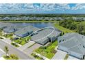 Aerial view of a lakeside neighborhood featuring a home with a brick driveway at 11685 Great Brook Ln, Parrish, FL 34219