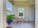 Cozy front porch with brick flooring, seating, and vibrant potted plants, creating a welcoming entrance at 11685 Great Brook Ln, Parrish, FL 34219